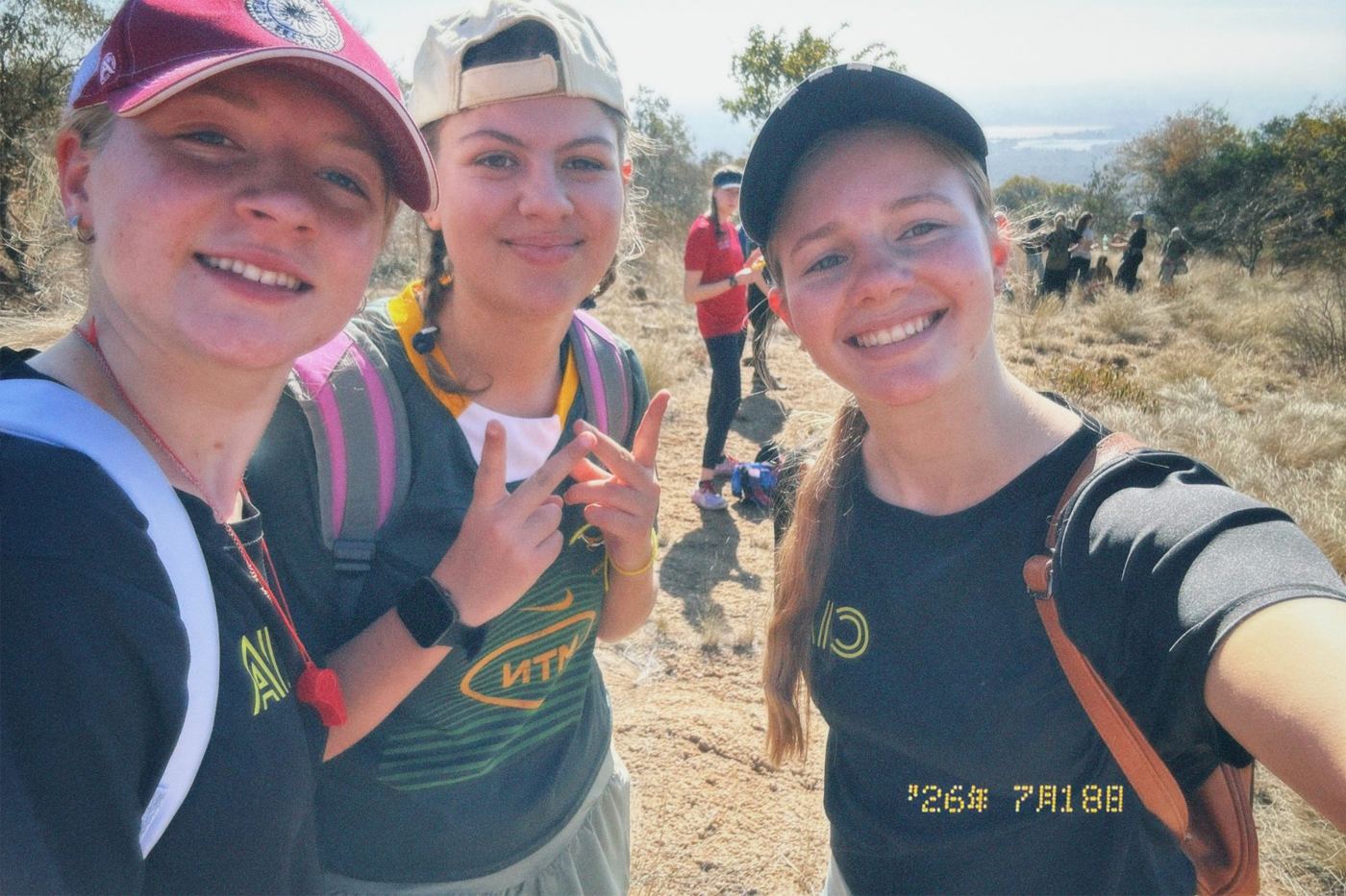 Three smiling girls taking a selfie on a hike at the CIA girls camp
